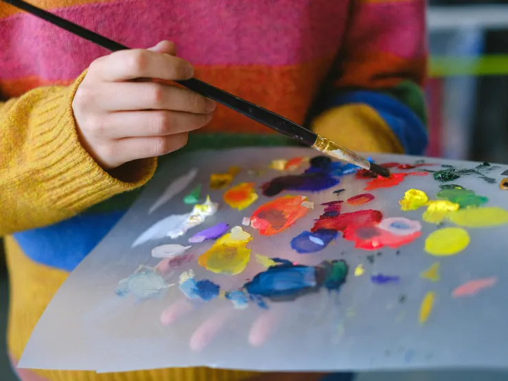 Artist mixing paint on a palette.