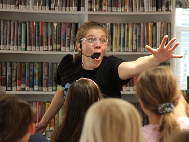 "Science Heroes" performer in front of bookshelves