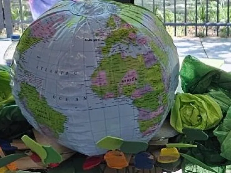 Cardboard hand with leaves for hands cupping a inflatable globe