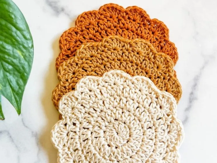 Three crochet coasters with different colors. 