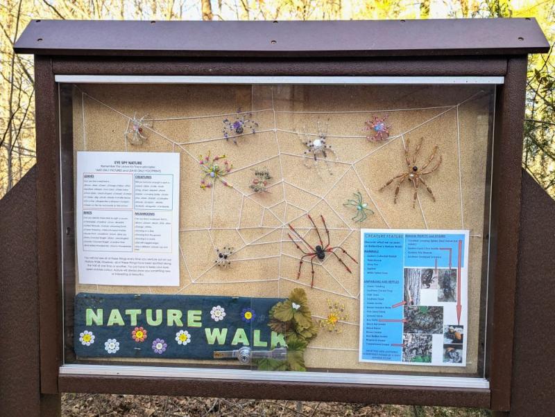 An image of the Trail Sign at Ballentine Library's Nature Walk, showcasing more beaded spiders