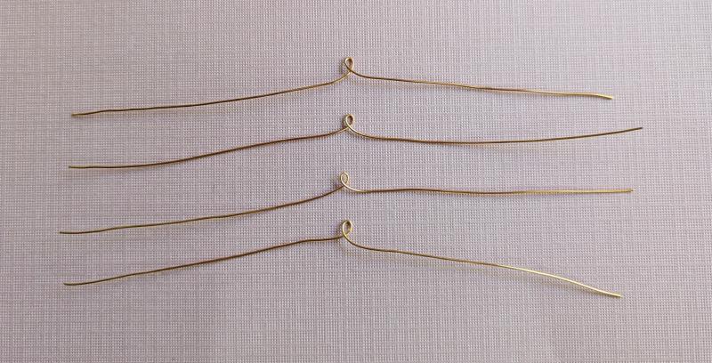 4 gold wires, each with a small loop in the middle