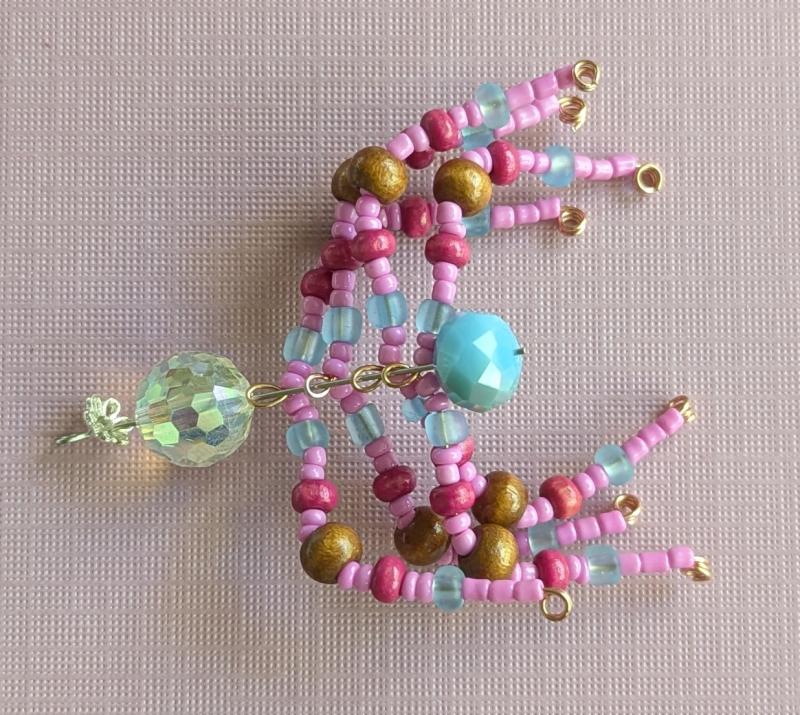 The various parts of the beaded spider stacked on an eye pin