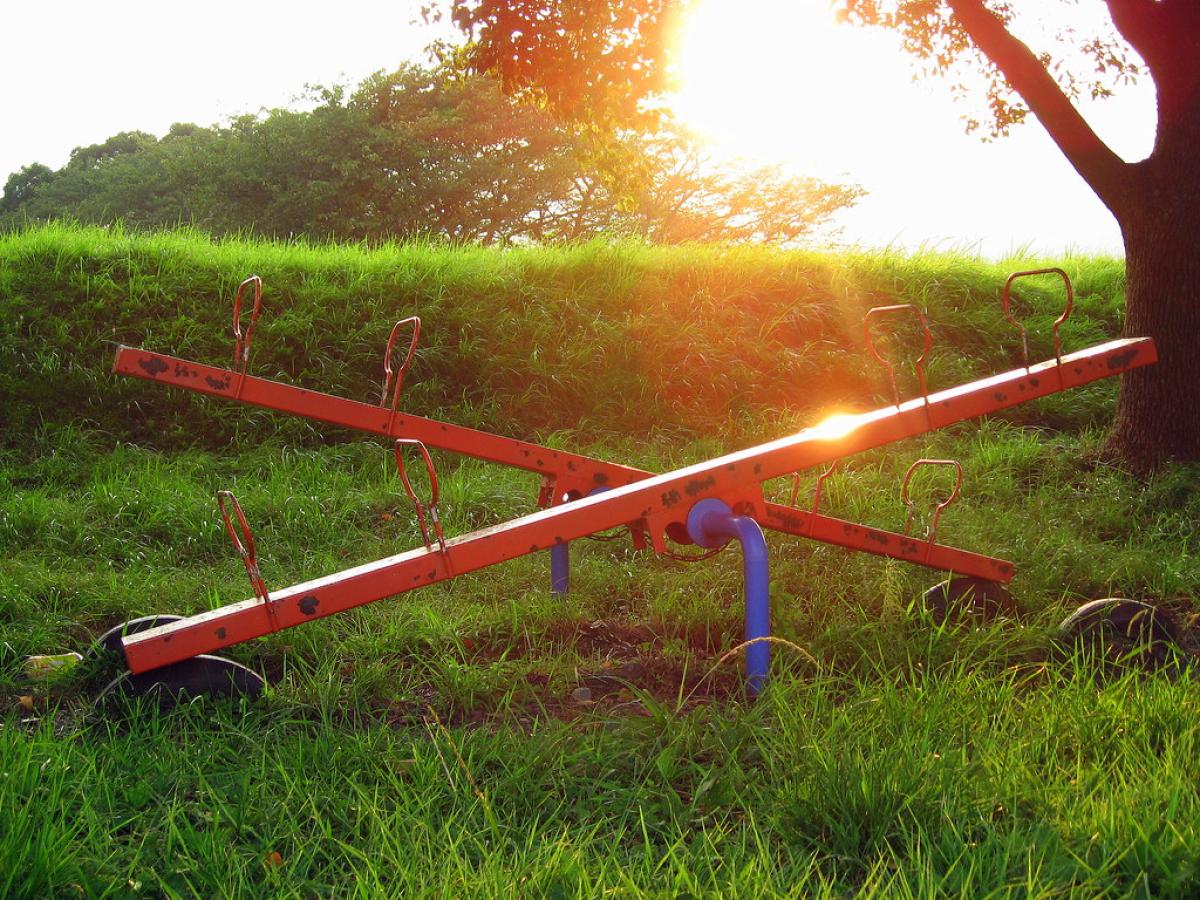A seesaw at dusk with the end of day sunlight shinning through it