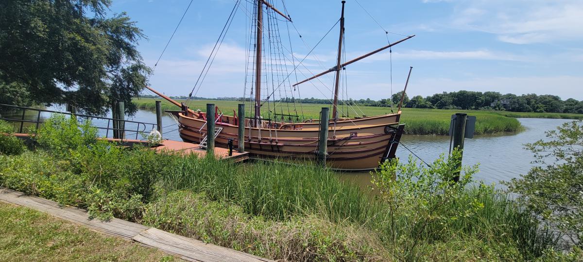 old ship docked near grass