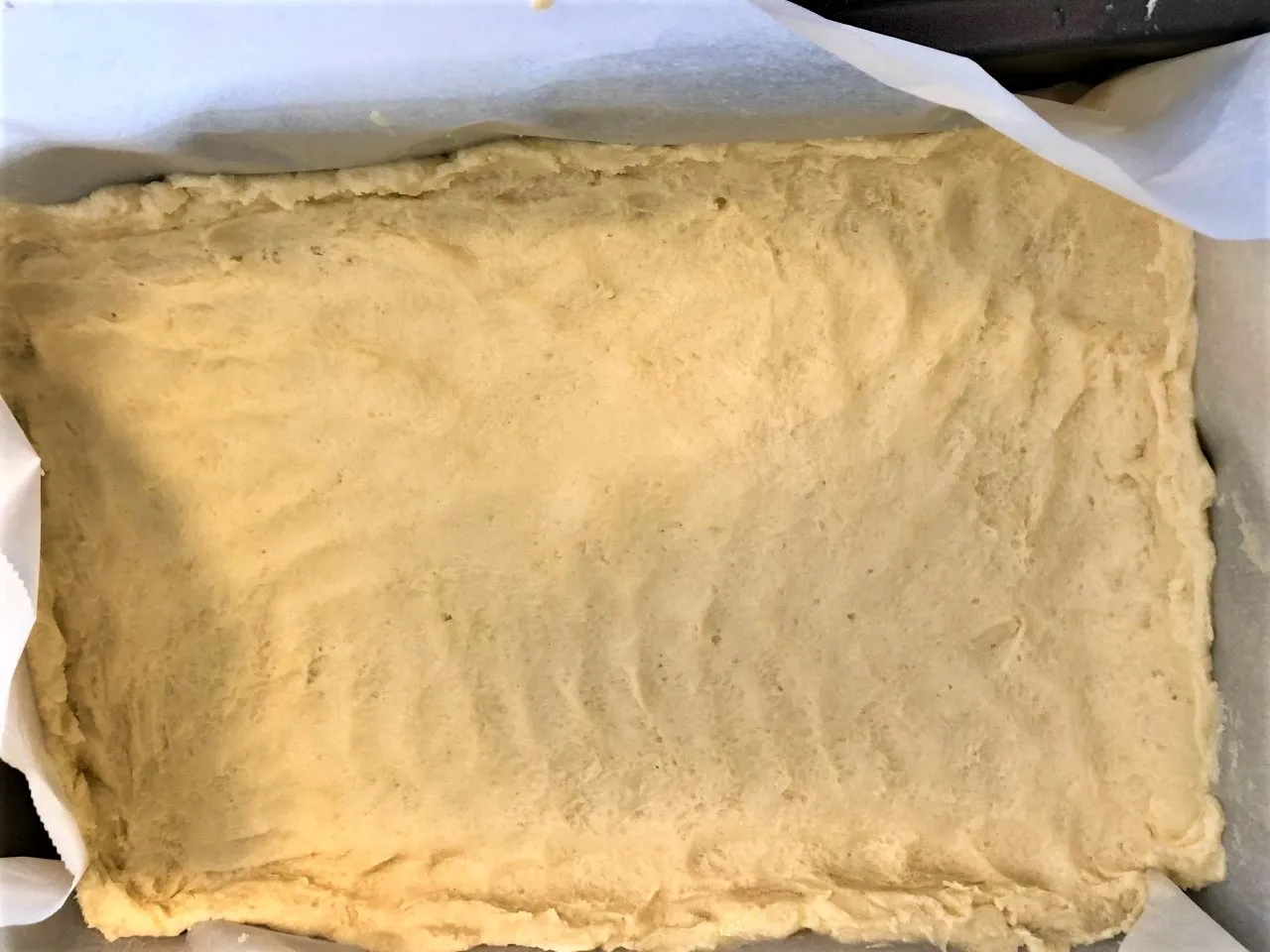 Image of dough for bottom crust of lemon bars covering the bottom of the baking sheet