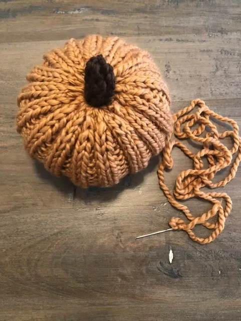 Knitted stem pushed into knitted pumpkin