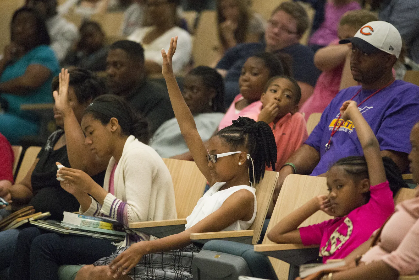 Children raise their hands during an event at Richland Library