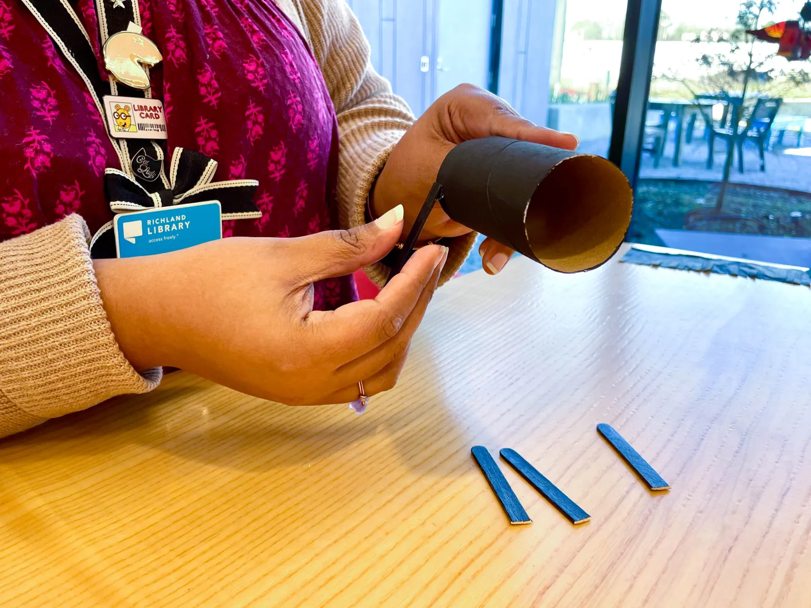 gluing popsicle sticks to toilet paper tube