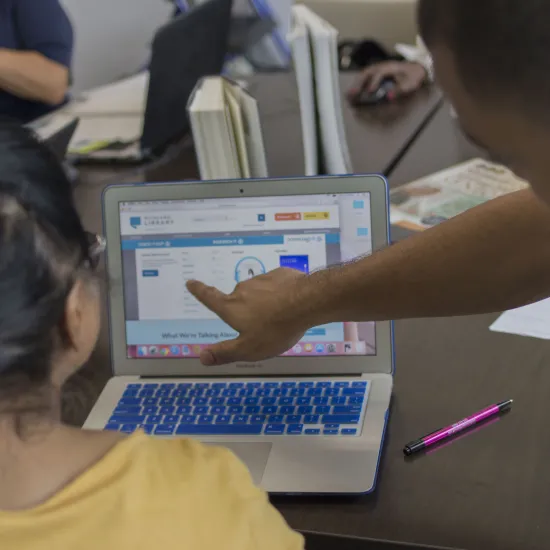 A man helps a woman use a computer