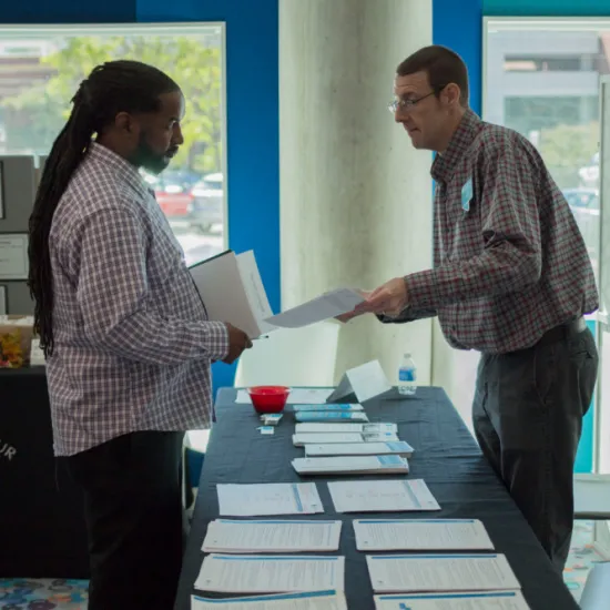 Staff member handing paper packet to guest