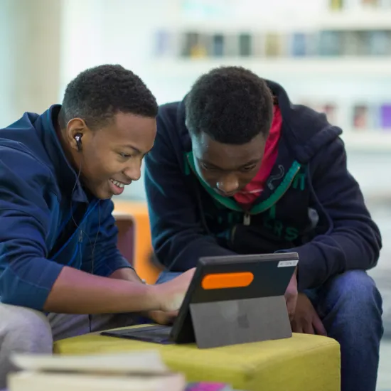 Teen boys looking at a tablet.