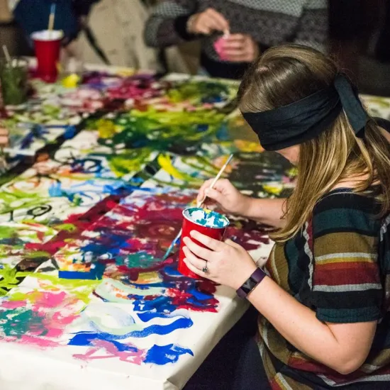 A woman paints blindfolded