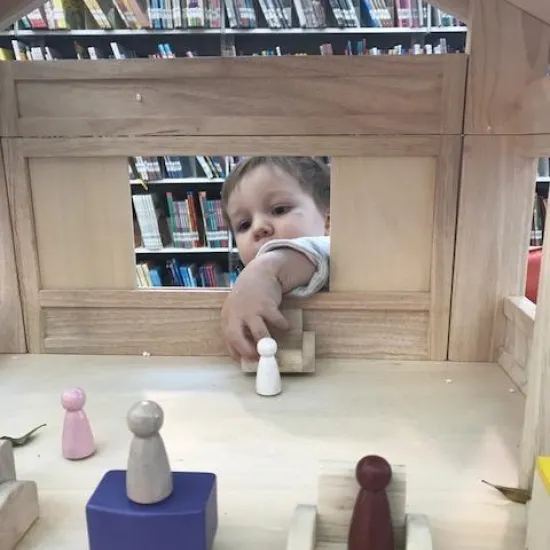 Preschooler plays with peg dolls