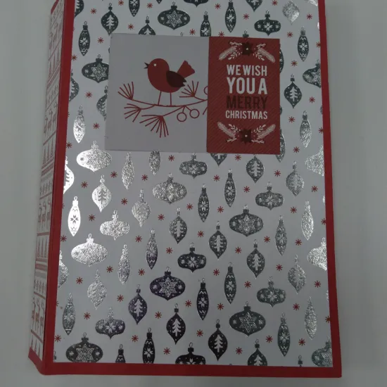 small handmade book with silver ornaments on the cover. red bird on a branch in the center of the book cover and text: "We wish you a merry Christmas"