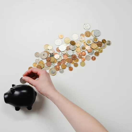 Coins being placed in a piggybank