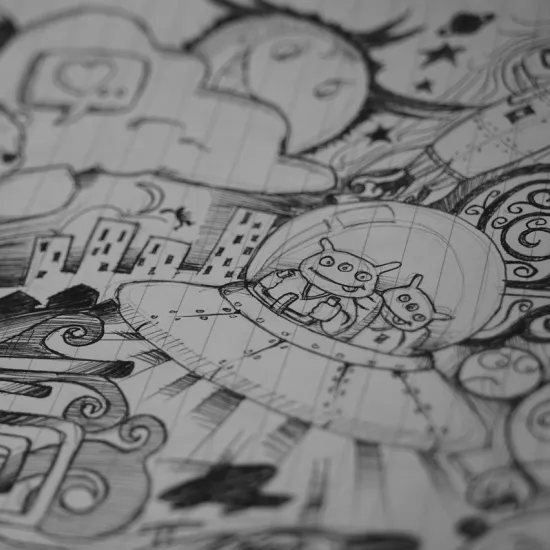 Photograph of black and white doodles, including aliens and a teddy bear