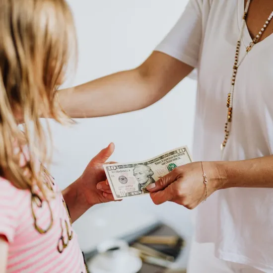 Parent giving ten dollars to child