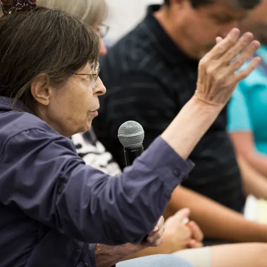 Woman talks animatedly in a crowd during an event at the library