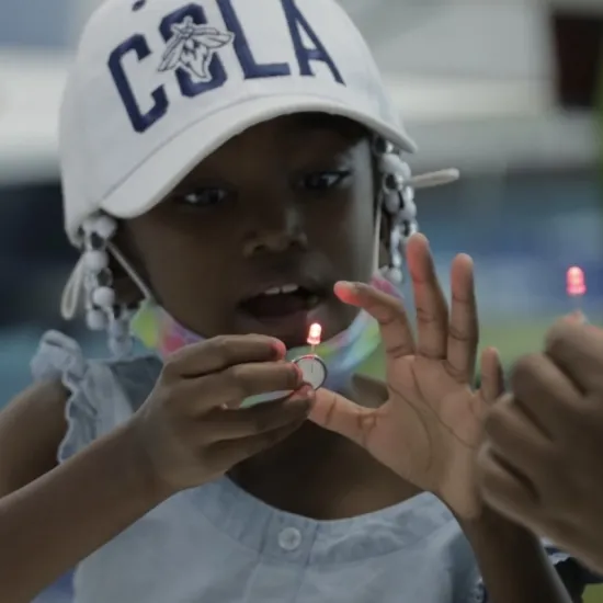 Girl in hat putting together LED Flash Light