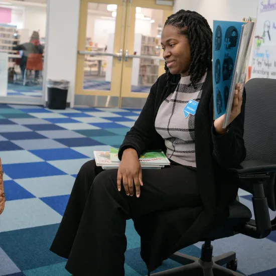 Library staff showing little boy a book one on one 