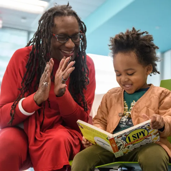 Grandmother and Grandson reading book and laughing 