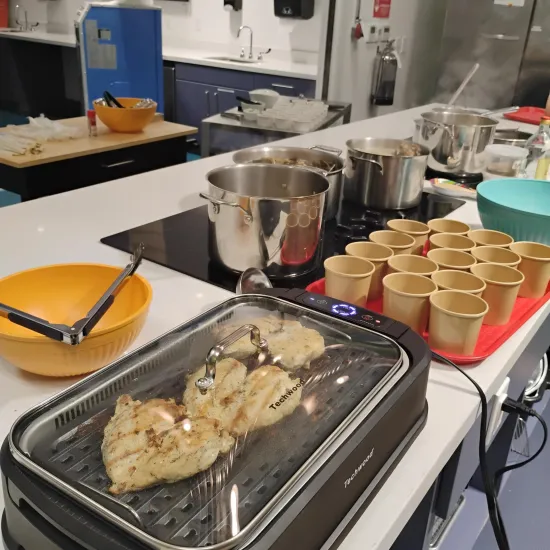 picture of cups and chicken cooking on an indoor grill